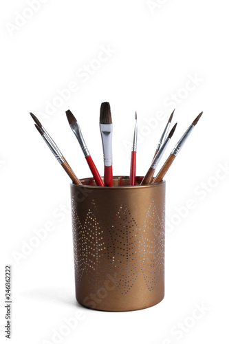 Holder with different paint brushes on white background