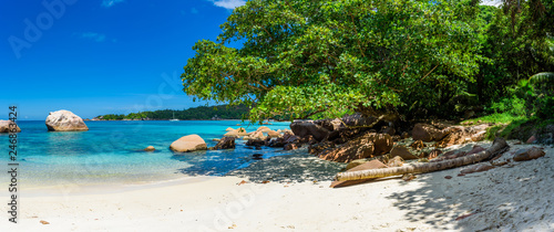 Seychelles beach in La Digue, stones and clear sea water