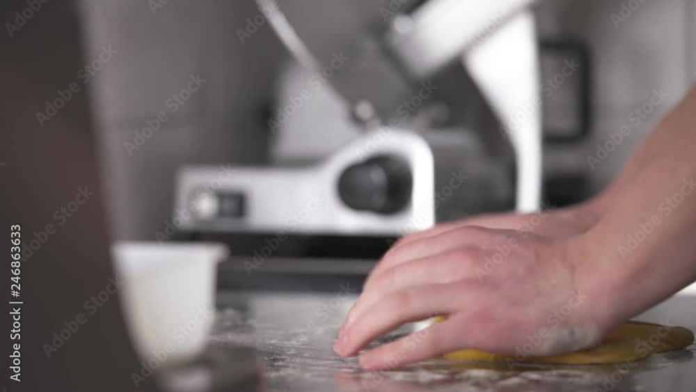 The bottom of the kitchen table, the camera moves bottom up and shows hands kneading a piece of dough on the table in the professional kitchen. Fresh noodles preparation in a restaurant The bottom of the kitchen table, the camera moves bottom up and shows hands kneading a piece of dough on the table in the professional kitchen. Fresh noodles preparation in a restaurant