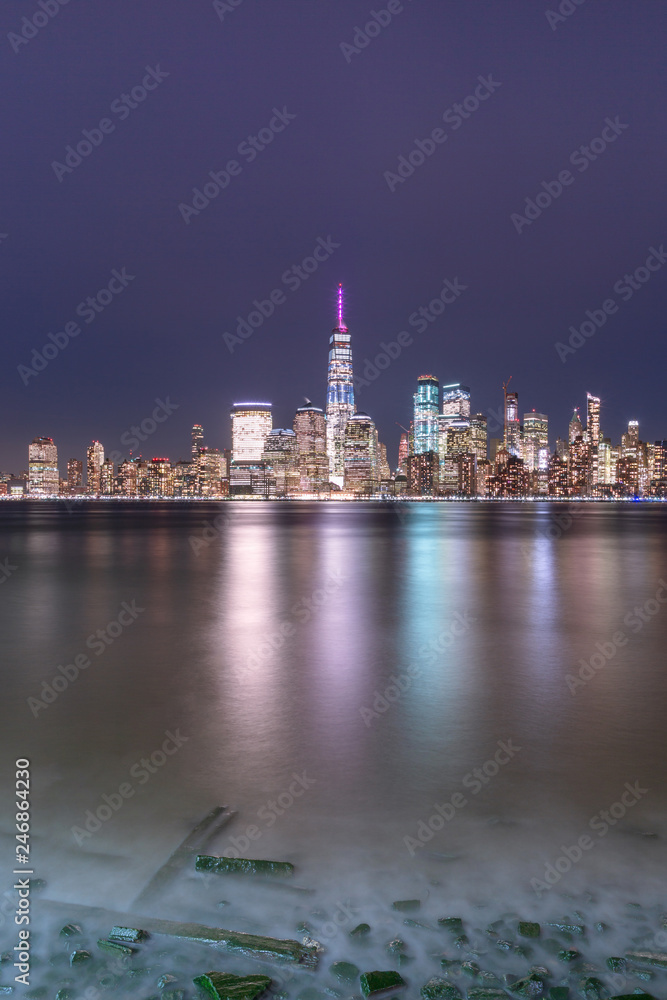 View on Financial district at night from Hudson river beach with long exposure