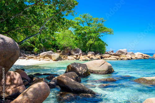 Seychelles beach in La Digue, stones and clear sea water