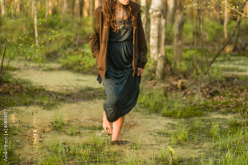 A young girl walks through the woods. The girl is resting in nature. Loneliness in modern society. Harmony with nature.