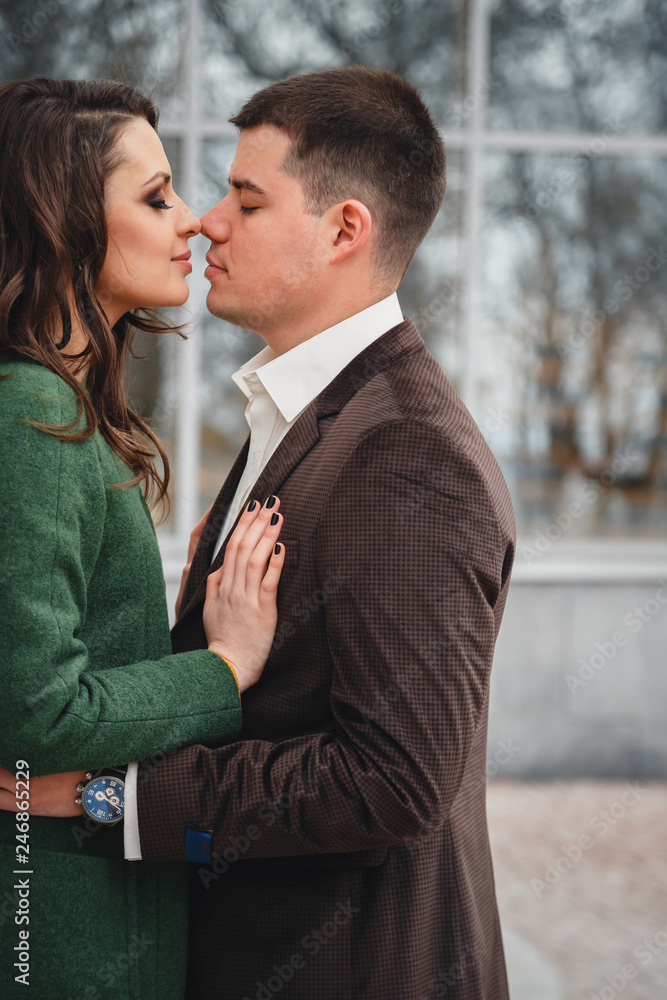Close up of happy romantic attractive young couple kissing and hugging at the street Close up of happy romantic attractive young couple kissing and hugging at the street