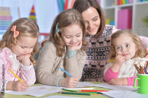 Portrait of mother and girls drawing together photo