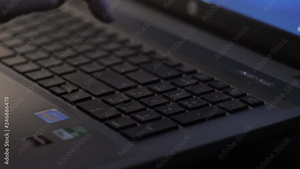 In the evening, a woman works on a laptop. Typing text In the evening, a woman works on a laptop. Typing text