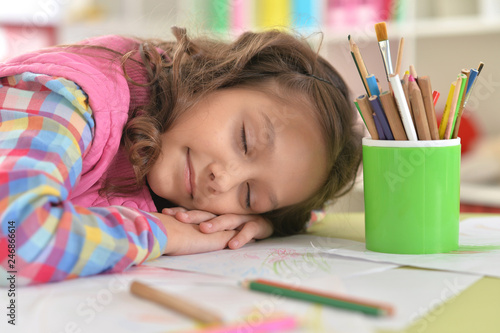 Portrait of cute schoolgirl sleeping on table