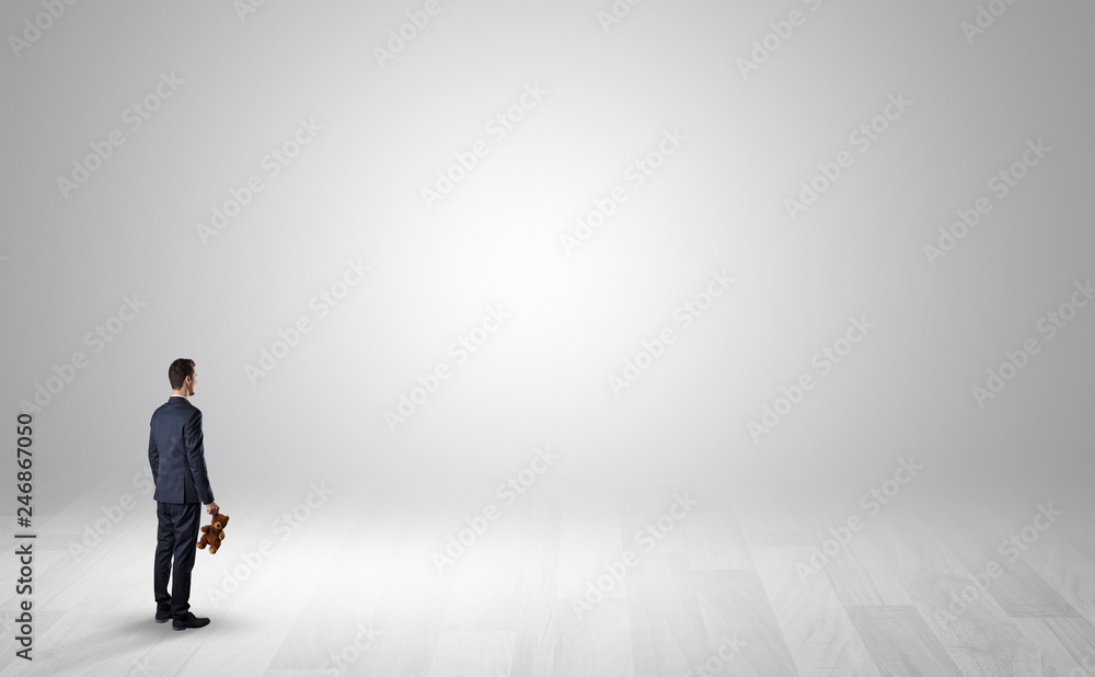 Man standing with his back in an empty room with object in his hand Man standing with his back in an empty room with object in his hand