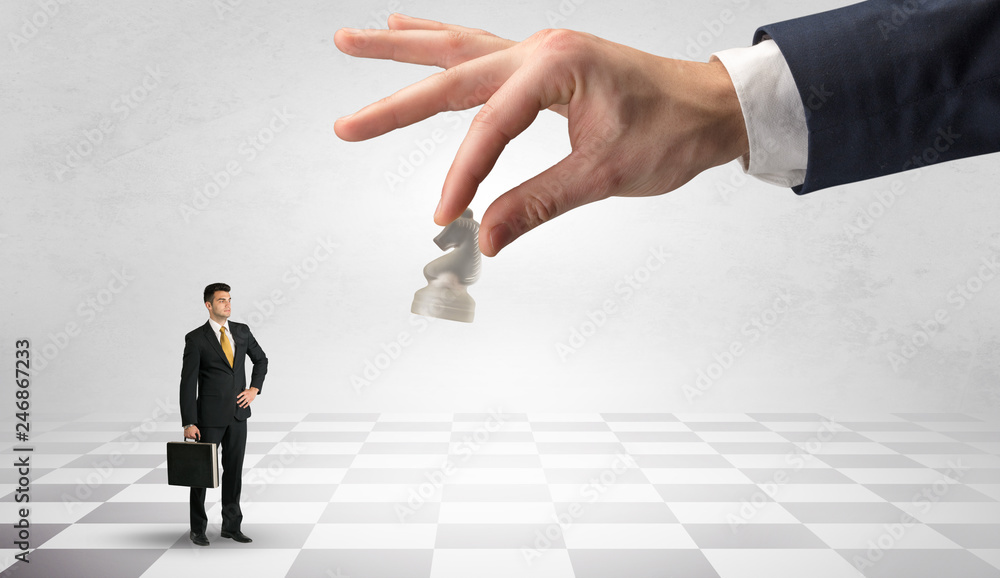 Small businessman fighting against big chessman on a big hand with chess board concept
Small businessman fighting against big chessman on a big hand with chess board concept