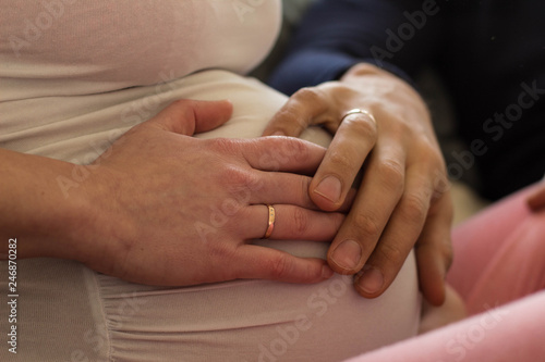 Schwangerschaftsbauch mit Händen bunt