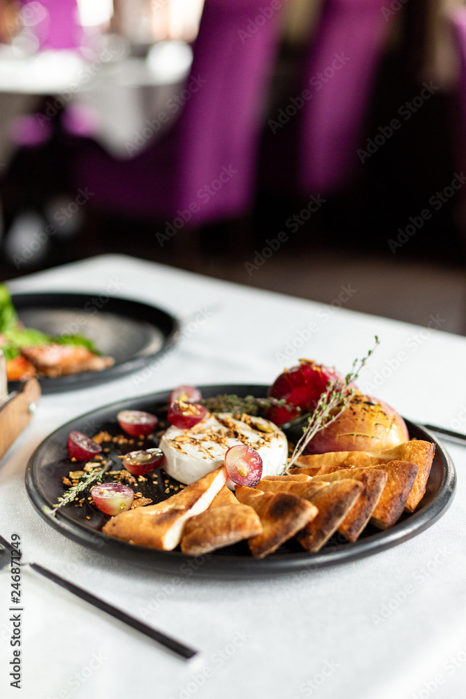 Grilled camembert with baked apple and grapes with slices of bread cakes Grilled camembert with baked apple and grapes with slices of bread cakes