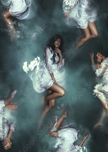 Fine art imagery. Selender girl in white dress underwater