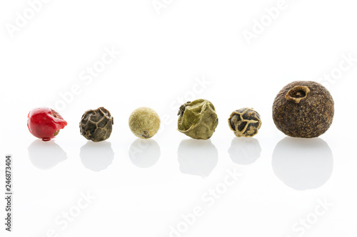 Spice. Allspice, black, white, green and red peppercorns with a pronounced texture close-up