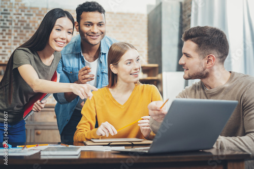 Pleased four students discovering solution