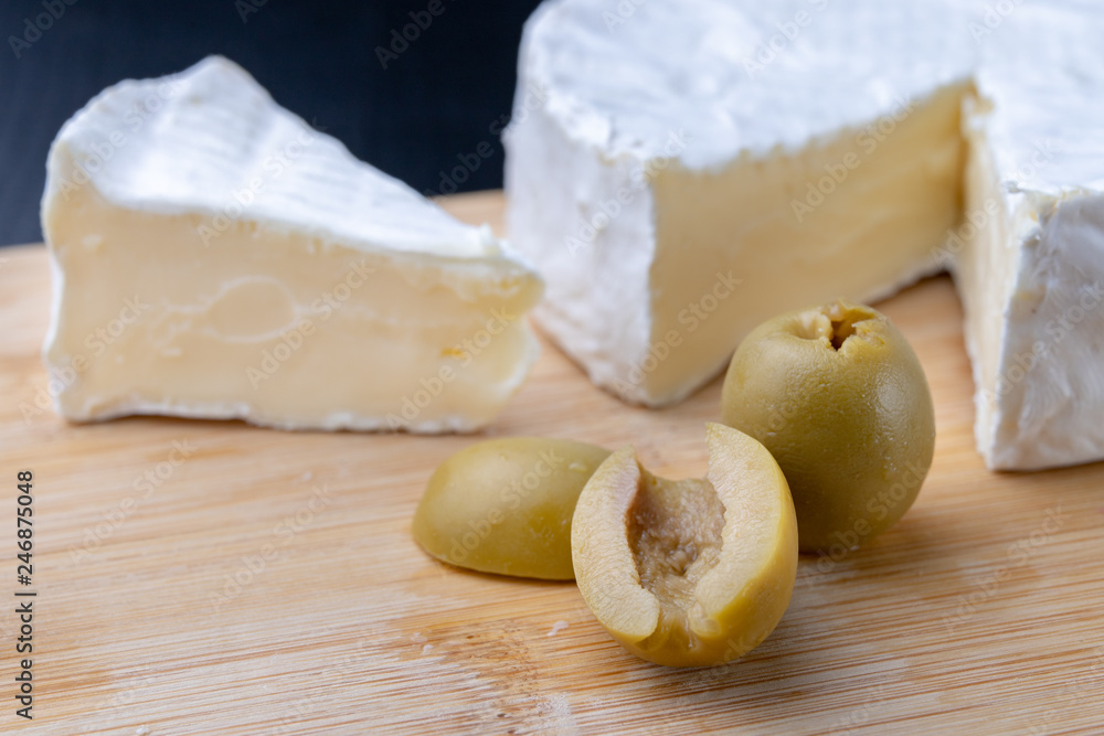 Tasty blue cheese on a wooden board. Prepared Italian dishes on the kitchen table. Tasty blue cheese on a wooden board. Prepared Italian dishes on the kitchen table.