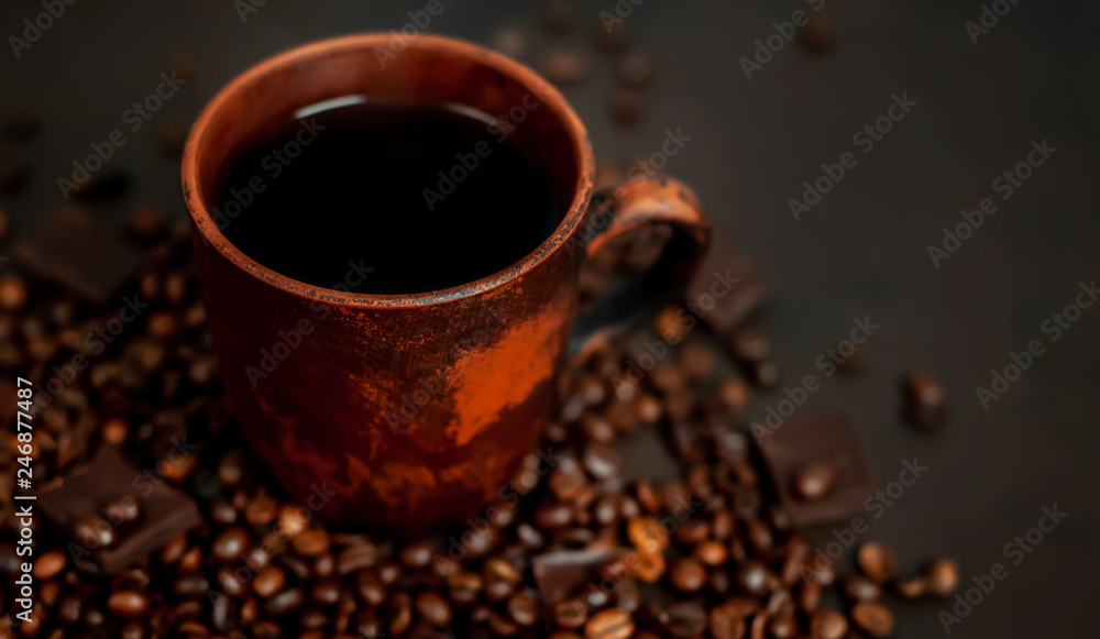 Coffee cup with roasted beans on stone background