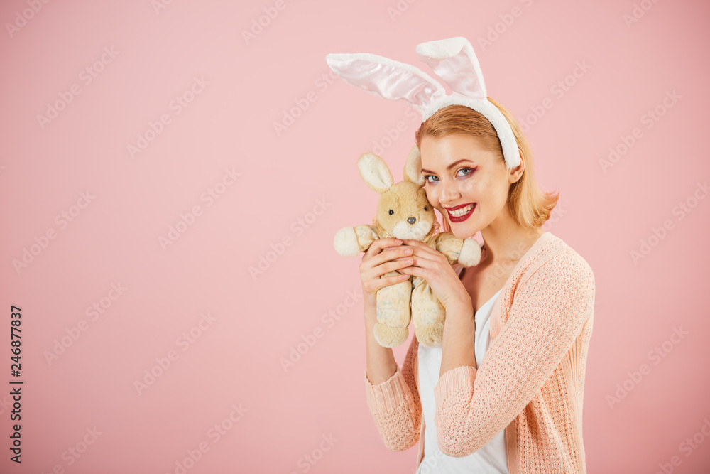 happy woman in bunny ears with toy. Spring holiday. Girl with hare toy. Happy easter. Egg hunt. Easter eggs as traditional food. Woman in rabbit bunny ears. copy space. Easter surprises