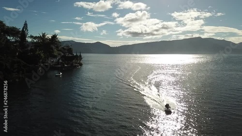 Drone view of jetski on lake Toba, near the coaastline of Samosir Island, Sumatra, Indonesia. photo