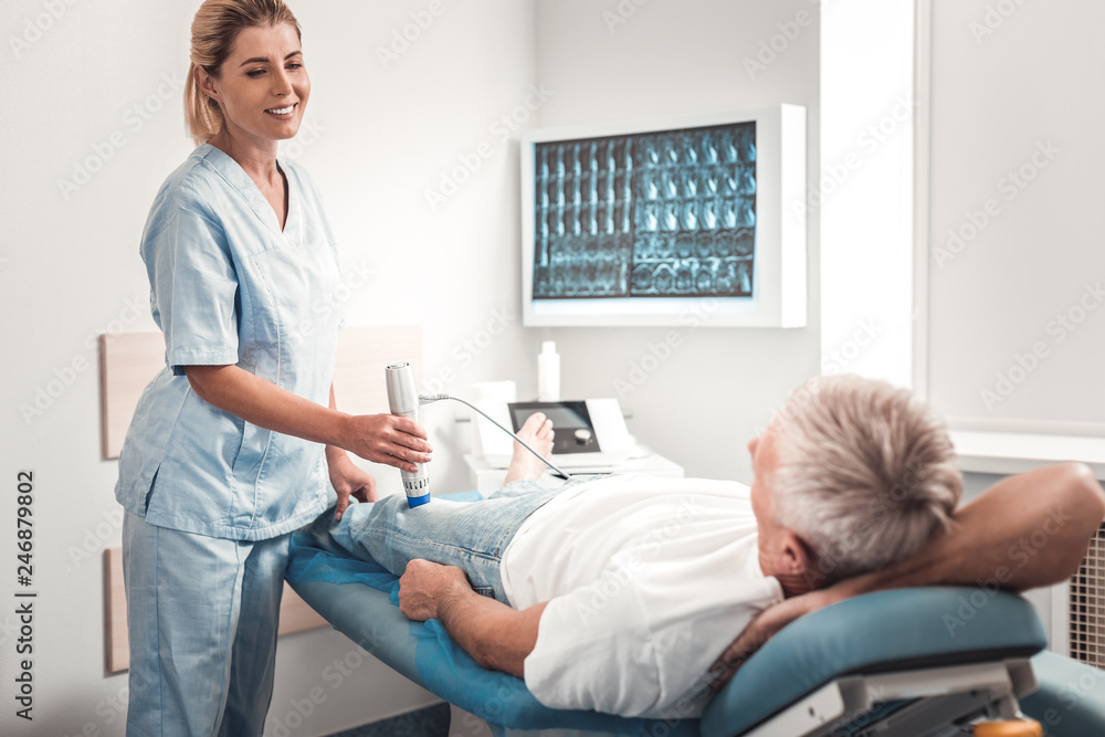 Fototapeta premium Blonde-haired chiropractor enjoying communicating with patient