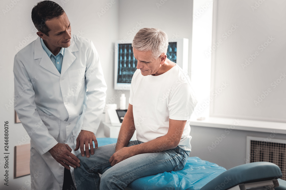 Retired man sitting and explaining his pain in knee Retired man sitting and explaining his pain in knee