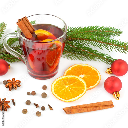 Hot red mulled wine isolated on white background with spices, orange slice, anise and cinnamon sticks.