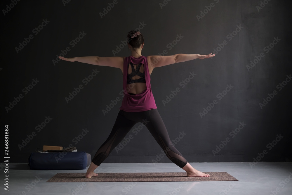 beautiful model doing yoga exercise. Preparing to do trikonasana posture.