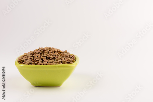 Yellow lentil in a bowl isolated on white background