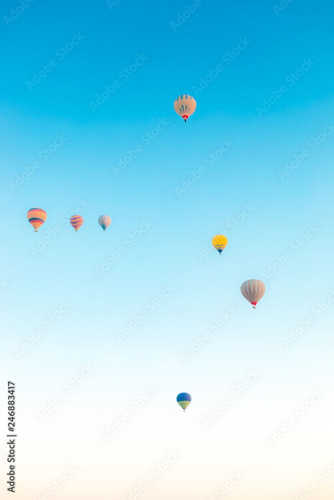Colorful hot air balloons isolated on blue sky background. Colorful hot air balloon flying over at fairy chimneys in Nevsehir, Goreme, Cappadocia Turkey. 