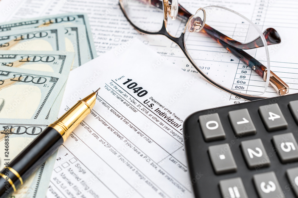 Pen, money, calculator and glasses on tax form. Pen, money, calculator and glasses on tax form.