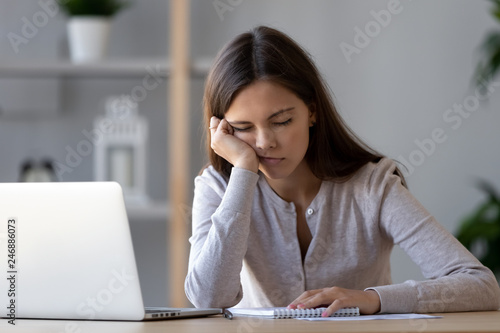 Tableau sur toile Bored at office work funny sleepy woman worker resting on hand sleeping at workp