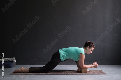 Young slim girl, doing horse rider exercise, anjaneyasana pose, working out. photo