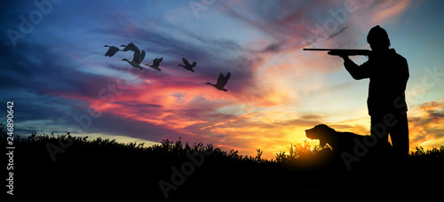 hunter with dog at sunset