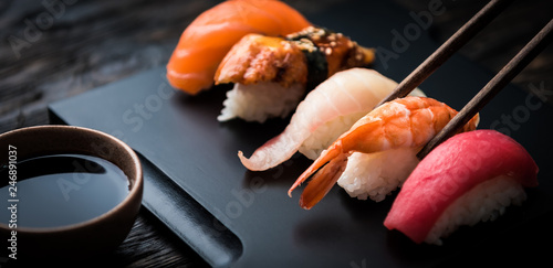 close up of sashimi sushi set with chopsticks and soy on black background photo