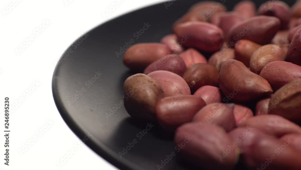 Raw unpeeled peanuts. Rotation. Snack closeup. Peanuts in a bowl. Selective focus. Isolated on white. Studio shot. Healthy food concept. Raw unpeeled peanuts. Rotation. Snack closeup. Peanuts in a bowl. Selective focus. Isolated on white. Studio shot. Healthy food concept.