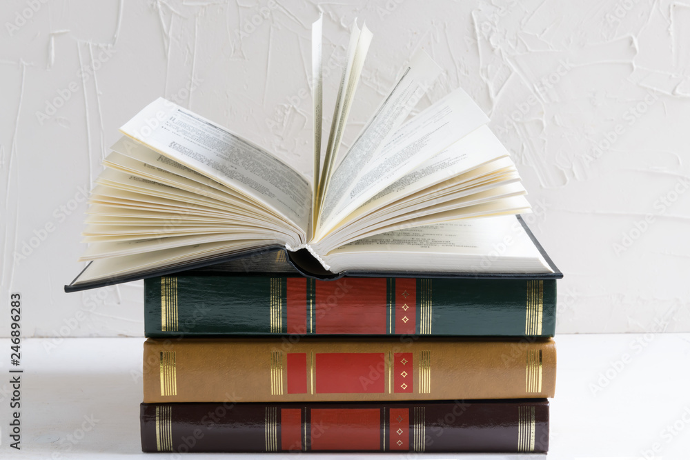 Naklejka premium Education and wisdom concept - open book on a stack of books