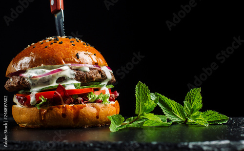 Delicious fresh homemade burger on black slate.