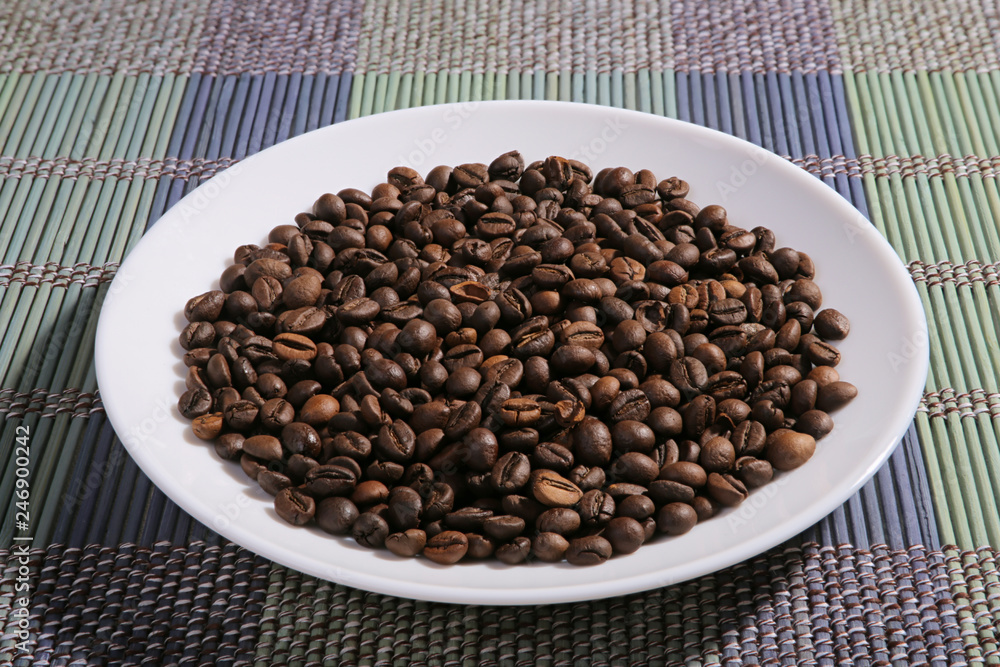 A scattering of coffee beans on a plate. A scattering of coffee beans on a plate.