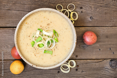 Fotografie Potato and leek soup. Top view on a rustic wood background.
