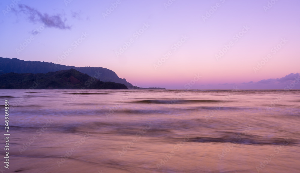 Sunrise lights the dawn sky above Hanalei Bay with the Na Pali coast in the background near Hanalei, Kauai, Hawaii Sunrise lights the dawn sky above Hanalei Bay with the Na Pali coast in the background near Hanalei, Kauai, Hawaii