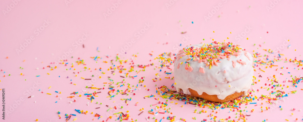 Sprinkle pink donut. on a pink background with space for design. Banner