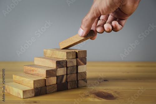 Closer up hands of businessmen,stacking wooden blocks into steps,Concept of business growth success - image