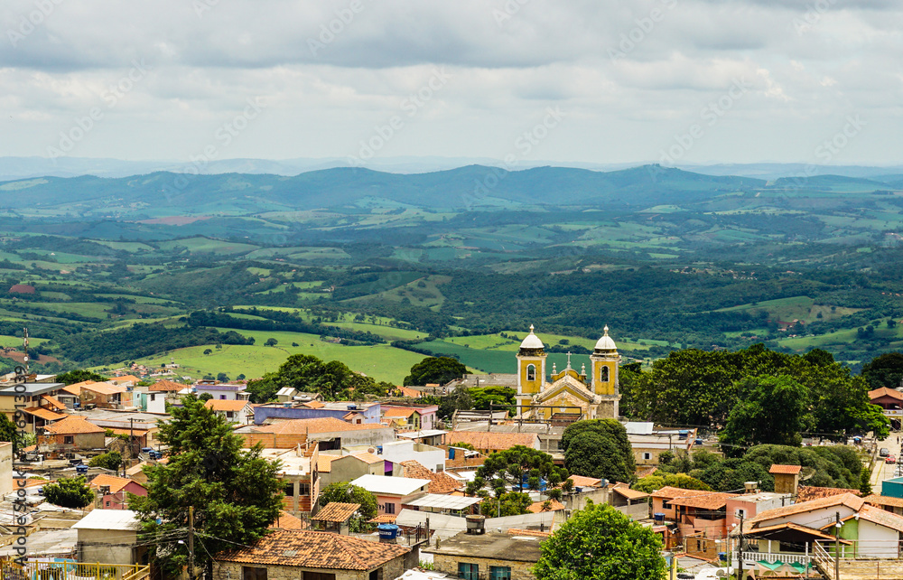 Panoramic view of São Thomé das Letras' downtown, with historical church in foreground and Minas Gerais' hilly landscape on background. Brazil.