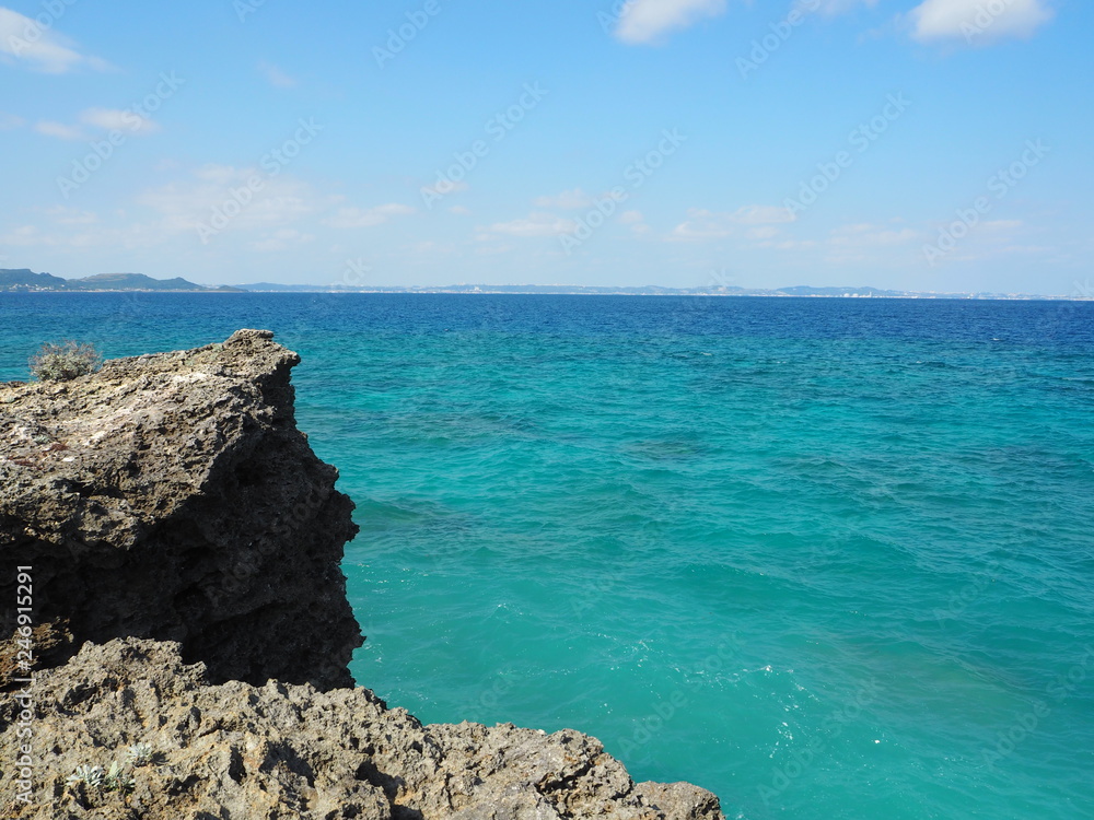 海岸の岩場とターコイズブルーの海、沖縄県久高島