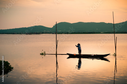 A fisherman standing in a boat in the lake Rawa Pening, Indonesia 