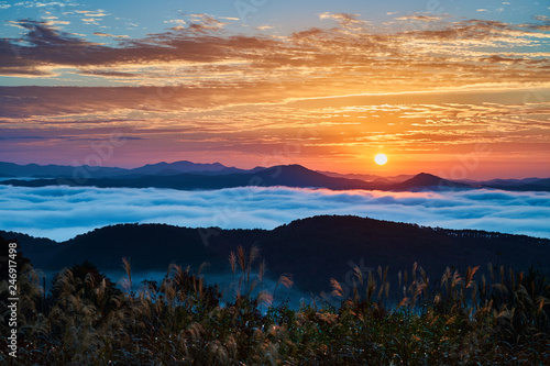 Autumn sunrise over the huge valley filled with cloud sea