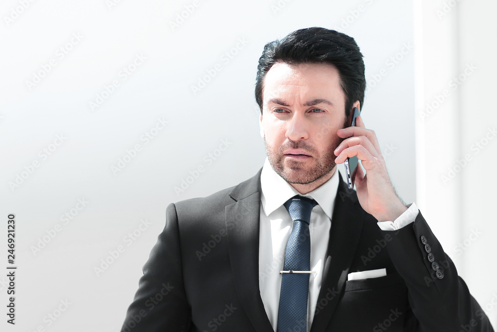 serious businessman talking on mobile phone serious businessman talking on mobile phone