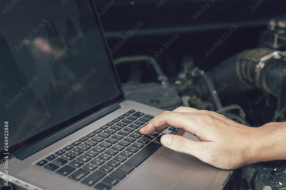 Car repair technicians use laptop computers to measure engine values for analysis. Car repair technicians use laptop computers to measure engine values for analysis.