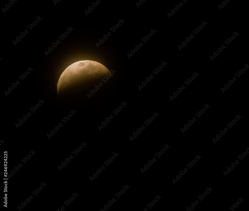 Full Lunar Eclipse in January 2019 is pictured in various stages of the eclipse. The bright white moon turns dark and black and eventually a yellowish orange that glows in the dark night sky Full Lunar Eclipse in January 2019 is pictured in various stages of the eclipse. The bright white moon turns dark and black and eventually a yellowish orange that glows in the dark night sky