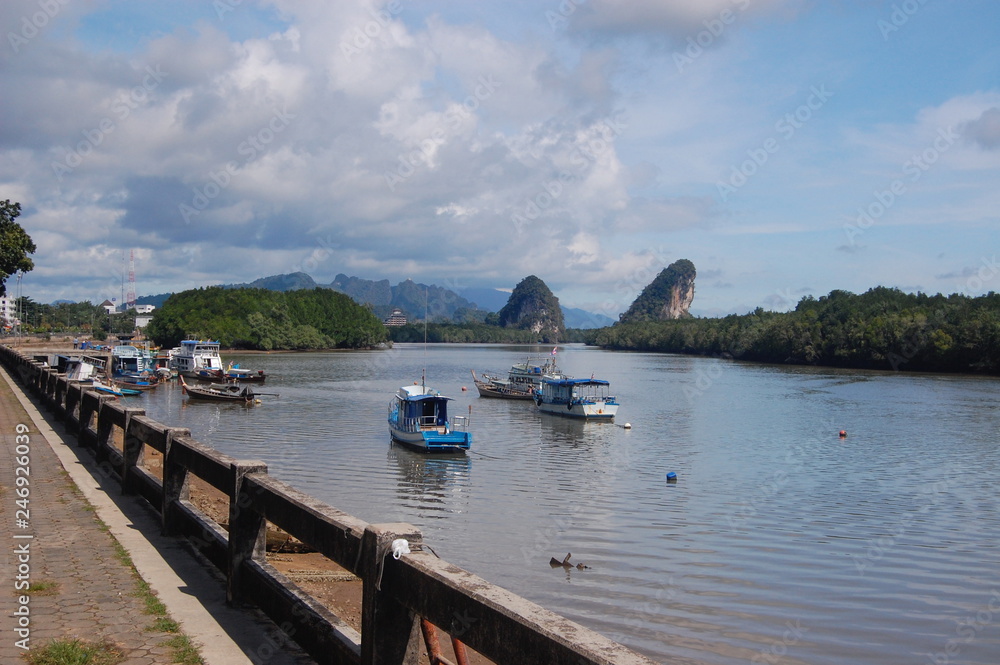 Krabi City View towards the Karst Mountains in Krabi, Southern Thailand in the beautiful blue sky with a river and boats in the background. 