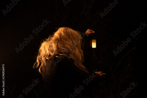 Silhouette of a woman holding lantern in the night. scary scene