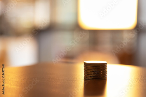 Coin on wooden table for finance and business concept with bokeh light of store on background.